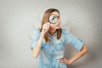 girl looking through a magnifying glass