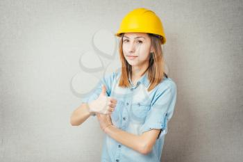 girl in the construction helmet showing thumbs up