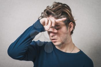Man headache, hand on his head. Gray background