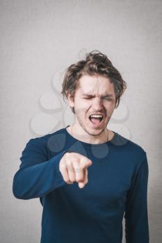 Man shows a finger forward. Gray background