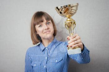Half-length portrait of business woman keeping gold cup, isolated on white. Concept of victory and success