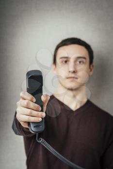 Man holding a landline telephone receiver 