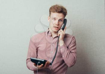 man talking on landline phone
