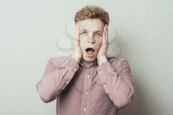 young man in shock with hands on face