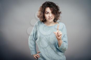 Portrait of young pensive woman pointing up. Isolated 