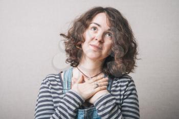 Joyful woman holding hands on his chest