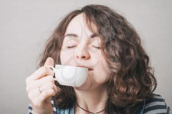 girl drinking coffee, dressed in overalls