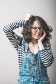 Woman angry cries on the phone. Gray background