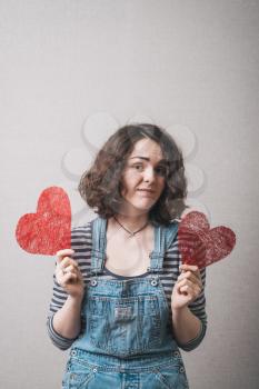 Love and valentines day woman holding heart smiling cute and adorable. Valentine's Day. Beautiful smiling woman with a gift in the form of heart in his hands