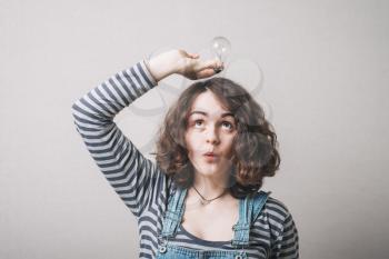 beautiful woman holding up a light bulbs in her hand