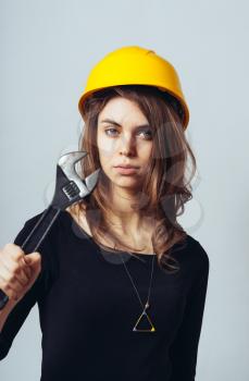 beautiful woman engineer with big screw key in helmet