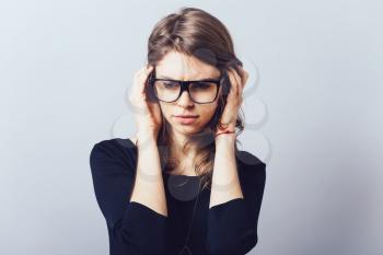 Woman in glasses, adjusts his glasses or hair on a grey background