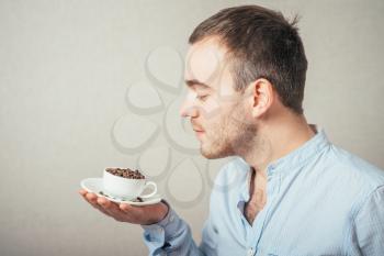 Smiling business-man holding cup filled with coffee beans