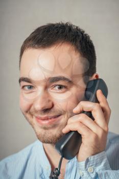 Man holding a telephone tube and smiling