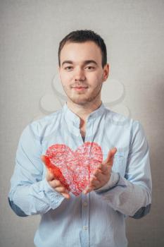 young man holding a heart