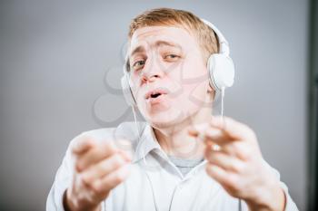 young man singing with loud music in the ears