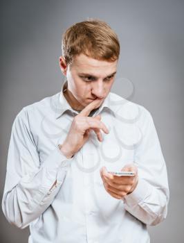 Bad news. Portrait of frustrated mature man in formalwear holding the mobile phone 