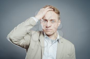 Closeup portrait of angry, frustrated man, hand on head. Negative human emotions and facial expressions