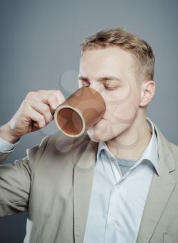 Portrait of handsome young man drink a cup tea, coffe, milk or other