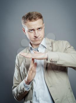 Close up Businessman in  Suit Showing Time Out Sign, Isolated on Gray Background.