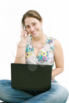 beautiful young woman talking over the phone and using laptop 

