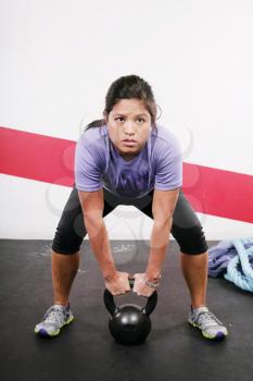 Portrait of young woman having a short break in her kettlebell crossfit workout 