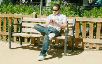  Young man text messaging in park 