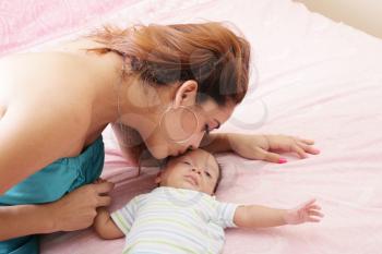 Young mother kissing her small newborn 