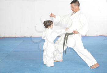 Teacher training karate to a little girl