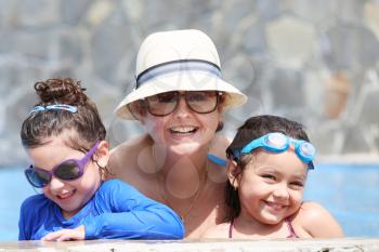 Happy mother with her kids in the pool