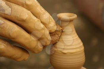 Close-up of fingers making pottery on a wheel