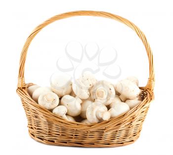 Fresh mushrooms in a wicker basket isolated on white background