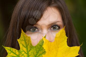 Royalty Free Photo of a Woman Covering Her Face With Leaves
