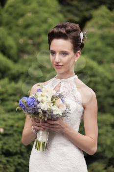 Young bride with bouquet in the park
