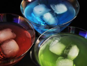cocktails with ice cubes on black background