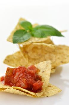Corn tortilla chips with salsa  on white background , close up