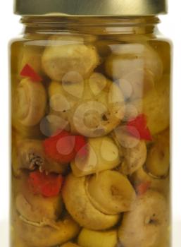 Glass jar of preserved mushrooms with red pepper , close up