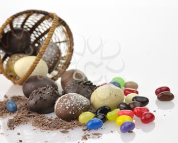 assortment of chocolate eggs , candies and  a basket, close up