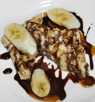 Waffles With Bananas And Chocolate Syrup For Breakfast
