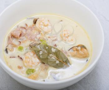 Creamy sea food soup in white plate , close up.