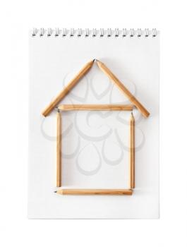 The house combined from pencils isolated on a white, notebook on background 