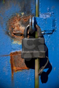 Black padlock on blue iron door 