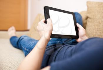 Man relaxing with tablet, laying on sofa