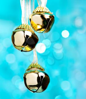 Christmas bells with ribbon, defocused blue lights on background 