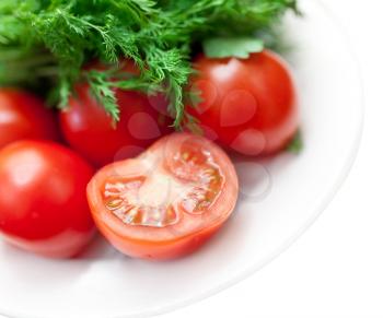 Fresh greens and tomatoes on white background
