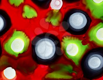 Green silver black spots on bright red.Colorful background hand drawn with bright inks and watercolor paints. Color splashes and splatters create uneven artistic modern design.
