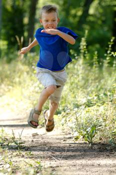 A Young boy running in nature