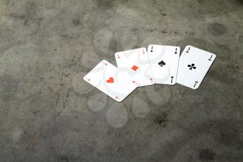 four aces on a cement floor