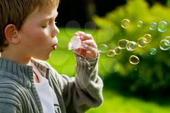 a little child blowing bubbles