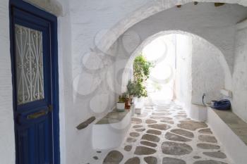 Classical narrow street with a painted sidewalk in Parikia